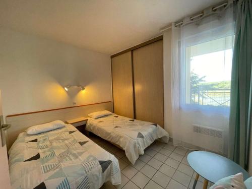 une chambre à l'hôpital avec deux lits et une fenêtre dans l'établissement Appartement 3 pièces avec balcon, piscine et parking à proximité de la mer - 6 couchages - FR-1-224C-188, à Saint-Jean-de-Monts