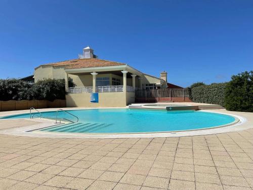 une grande piscine devant une maison dans l'établissement Appartement 3 pièces avec balcon, piscine et parking à proximité de la mer - 6 couchages - FR-1-224C-188, à Saint-Jean-de-Monts