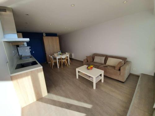 un salon avec un canapé et une table dans l'établissement Studio cabine 4 couchages, Saint-Jean-de-Monts, balcon, parking, à 2 pas de l'océan - FR-1-224C-194, à Saint-Jean-de-Monts