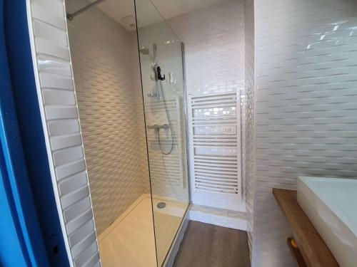 une douche avec une porte vitrée dans une salle de bain dans l'établissement Studio cabine 4 couchages, Saint-Jean-de-Monts, balcon, parking, à 2 pas de l'océan - FR-1-224C-194, à Saint-Jean-de-Monts