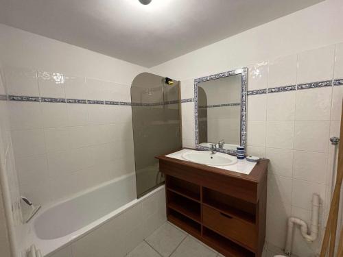 une salle de bain avec un lavabo, une baignoire et un miroir dans l'établissement Charmante maison avec jardin, parking, piscines chauffées à 2 pas de l'océan - St Jean de Monts - FR-1-224C-46, à Saint-Jean-de-Monts