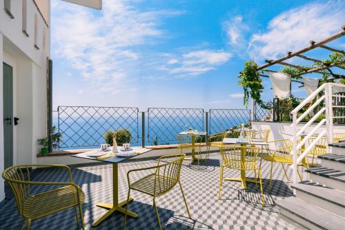 a patio with chairs and tables on a balcony at La Vigna di Bacco in Furore