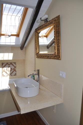 een badkamer met een wastafel en een spiegel aan de muur bij Casa di Mario appartamento in centro storico con due camere da letto e terrazze in Cagliari
