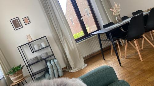 a living room with a table and chairs and a window at Huis Louis in Kortessem