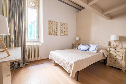 een witte slaapkamer met een bed en een raam bij Central and Roomy near the Station and Duomo - HomeUnity in Florence