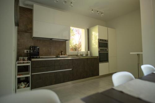 uma cozinha com armários brancos e uma janela em Ca' Ottantanove em Mestre