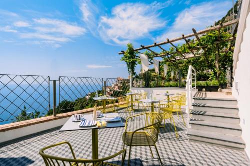 a patio with tables and chairs on a balcony at La Vigna di Bacco in Furore