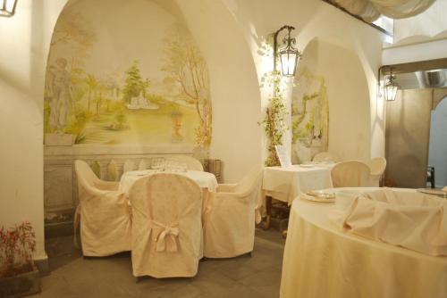 a dining room with two tables with white table cloth at Hotel del Real Orto Botanico in Naples