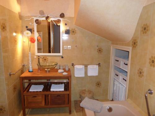uma casa de banho com uma banheira e um lavatório e uma banheira em Gîte Cravant-les-Côteaux, 6 pièces, 10 personnes - FR-1-381-395 em Cravant-les-Coteaux