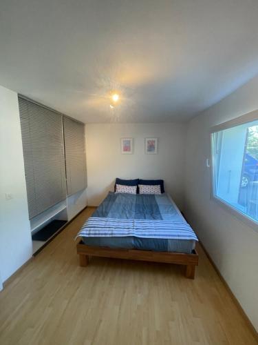 - une chambre avec un lit dans une pièce dotée d'une fenêtre dans l'établissement Happy Connection, à Villarvolard
