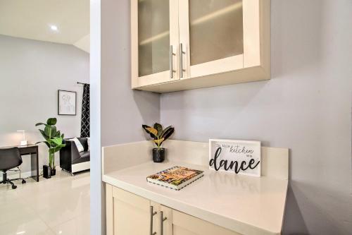 a kitchen with white cabinets and a book on a counter at Lovely Lauderhill Retreat Less Than 12 Mi to Beach! in Lauderhill