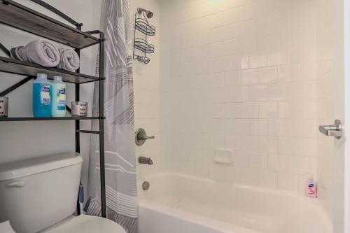 a bathroom with a white tub and a toilet at Spacious Denver Townhome Near Central Park! in Denver