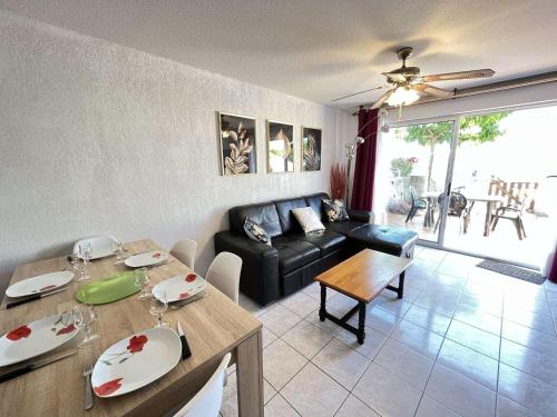 un salon avec une table et un canapé dans l'établissement Maison climatisée avec parking et terrasses, 2 chambres, quartier calme - FR-1-387-68, à Marseillan