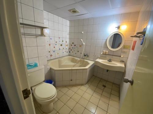 a bathroom with a toilet and a tub and a sink at 知本溫泉小燕的家 in Wenquan