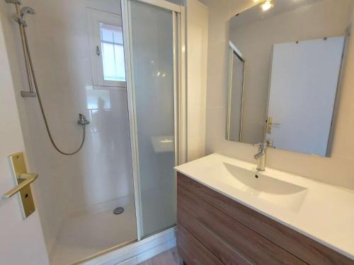 une salle de bain avec un lavabo et une douche avec un miroir dans l'établissement Appartement lumineux 4-6 pers avec terrasse, parking et cuisine équipée à Marseillan - FR-1-326-502, à Marseillan