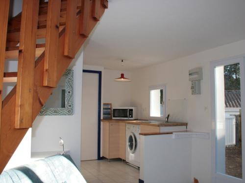 - une cuisine avec des murs blancs et un escalier dans une maison dans l'établissement Maison de vacances à La Terrière, 300m de la plage, proche forêt, 4 pers, parking, animal accepté - FR-1-22-187, à La Tranche-sur-Mer