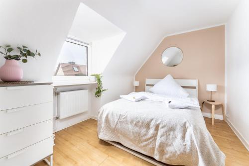 um quarto branco com uma cama e uma janela em Stay Awesome - Modernes Apartment am Botanischen Garten em Kassel