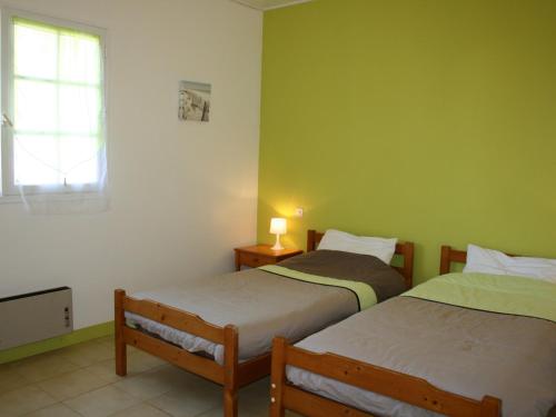 twee bedden in een kamer met groene muren bij Maison La Tranche-sur-Mer, 6 pièces, 8 personnes - FR-1-22-249 in La Tranche-sur-Mer