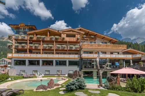 um hotel com piscina e um resort em Croce Bianca Leisure & Spa Hotel em Canazei