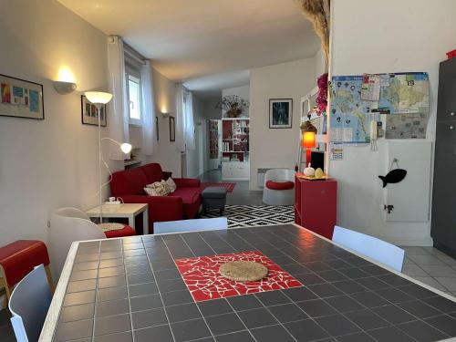 un salon avec une table et un canapé rouge dans l'établissement Bel appartement 3 pièces proche plage des Dames à Noirmoutier - FR-1-224B-179, à Noirmoutier-en-l'lle