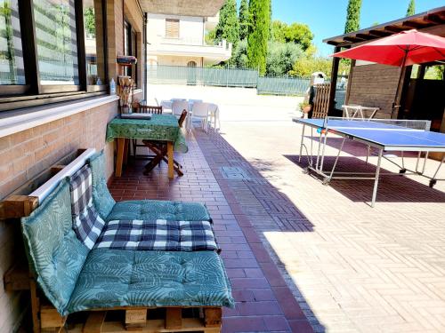 eine Tischtennisplatte und eine Bank auf einer Terrasse in der Unterkunft Itaca in Lido di Fermo