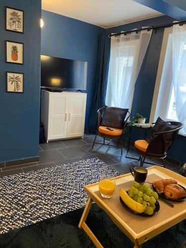 ein Wohnzimmer mit einem Tisch voller Obst in der Unterkunft Le Duplex du Beffroi in Douai