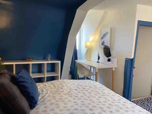 een slaapkamer met een bed, een tafel en een raam bij Le Duplex du Beffroi in Douai