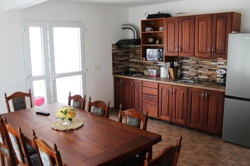 a kitchen with a wooden table and a refrigerator at VILA ONIX in Săcueni