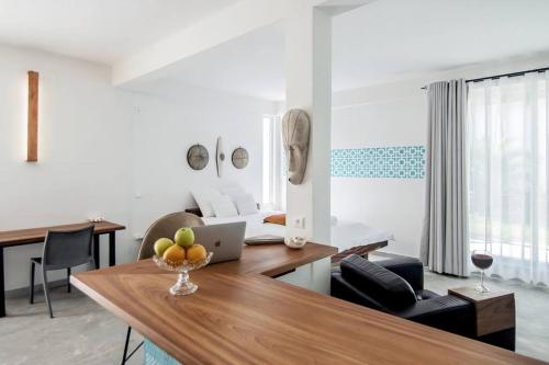 a living room with a table with a laptop on it at Contemporary Private Studio with Pool and Kitchen in Beira
