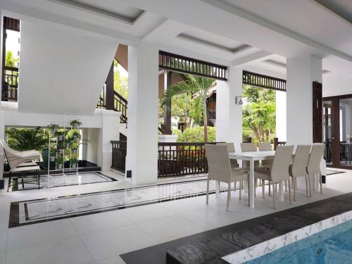 a dining room with a table and chairs and a pool at Sclass 2 Luxe Pools Villa & Breakfast , city area in Chiang Mai