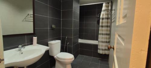 y baño con aseo blanco y lavamanos. en Ipoh Premier Suites @ Kinta Riverfront by DDV, en Ipoh