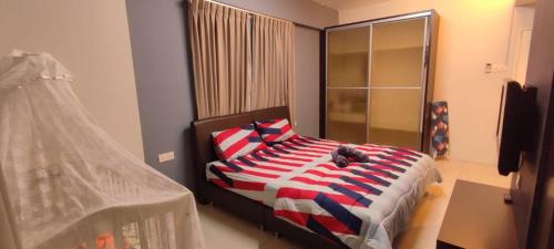 sypialnia z łóżkiem z białymi i niebieskimi poduszkami w obiekcie Ipoh Premier Suites @ Kinta Riverfront by DDV w mieście Ipoh