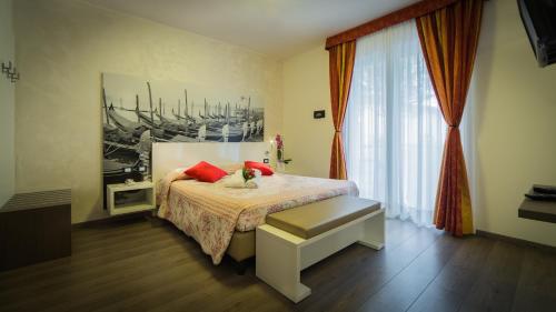 a bedroom with a bed with red pillows on it at Hotel Venezia in Caorle