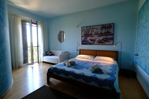 a blue bedroom with a bed and a couch at Sotto la luna Casa in campagna in Castel Bolognese