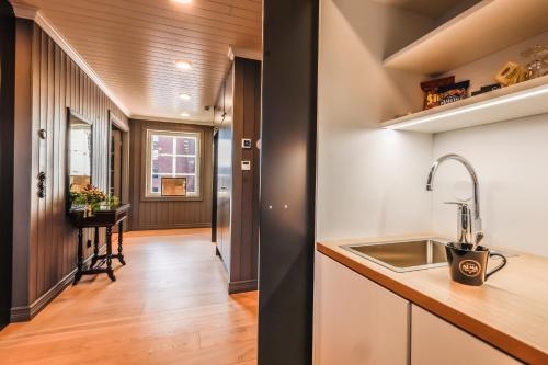 a kitchen with a sink and a hallway at Hotelli-Ravintola Alma in Seinäjoki