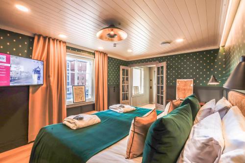 a bedroom with two beds and a tv in it at Hotelli-Ravintola Alma in Seinäjoki