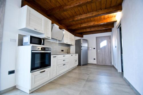 a kitchen with white cabinets and a refrigerator at Villa Infinity in Tergu