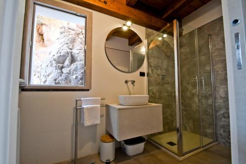 a bathroom with a sink and a shower with a mirror at Villa Infinity in Tergu