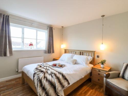 a bedroom with a bed with a tray of food on it at Cherry Blossom Place in Tiptree