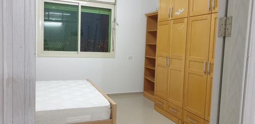 - une chambre avec un lit et une fenêtre dans l'établissement Nice Apartment in Hebron Palestine, à Khirbat an Naşārá