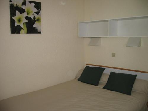 ラ・プラーニュにあるAppartement La Plagne, 2 pièces, 4 personnes - FR-1-353-45のベッドルーム1室(ベッド1台、緑の枕2つ付)