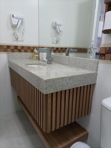 a bathroom with a sink and a mirror at Studio unita143 in Praia Grande