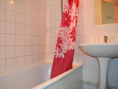 La salle de bains est pourvue d'un rideau de douche rouge à côté d'un lavabo. dans l'établissement Maison Familiale 4 Couchages avec Piscine à 700m de la Plage, Argelès-sur-Mer - FR-1-225-619, à Argelès-sur-Mer