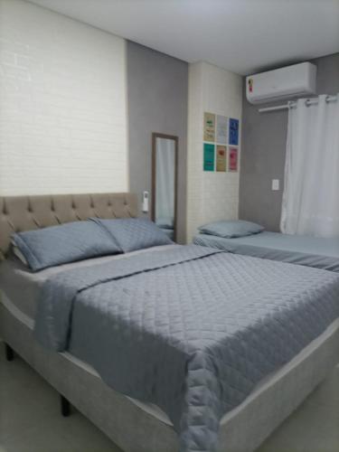 a bedroom with two beds with blue pillows at Studio unita143 in Praia Grande