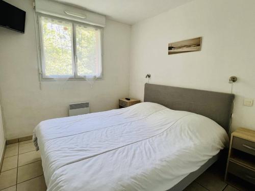 1 cama blanca en un dormitorio con ventana en Appartement Cambo-les-Bains, 2 pièces, 2 personnes - FR-1-495-72, en Cambo-les-Bains