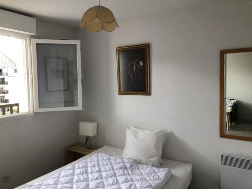 - une chambre avec un lit et une photo sur le mur dans l'établissement Appartement Cabourg, 2 pièces, 2 personnes - FR-1-487-313, à Cabourg
