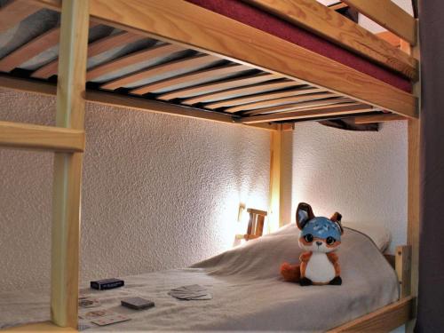 un animal farci assis au-dessus d'un lit superposé dans l'établissement Studio rénové 4 pers avec balcon Sud à proximité centre station Risoul 1850 - FR-1-330-503, à Risoul