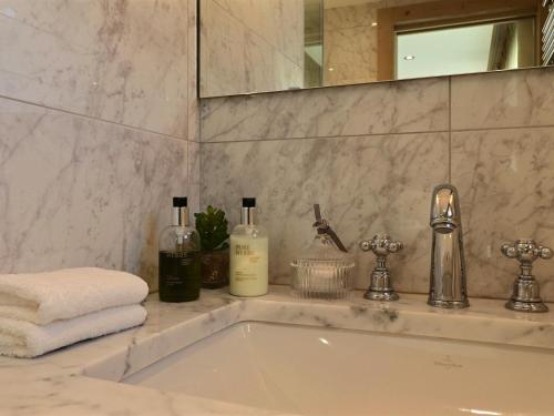 ein Bad mit einem Waschbecken und einem Spiegel in der Unterkunft Chalet Les Gets, 8 pièces, 14 personnes - FR-1-627-1 in Les Gets