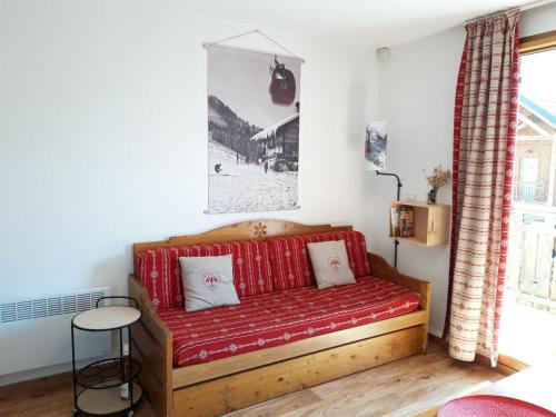 un sofá rojo en una sala de estar con mesa en Appartement Albiez-Montrond, 2 pièces, 4 personnes - FR-1-618-1, en Albiez-Montrond