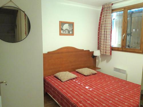 - une chambre avec un lit doté d'une couverture rouge et d'un miroir dans l'établissement Spacieux appartement 3* à 300m des pistes et commerces, balcon sud, parking, fin de séjour inclus - FR-1-618-1, à Albiez-Montrond